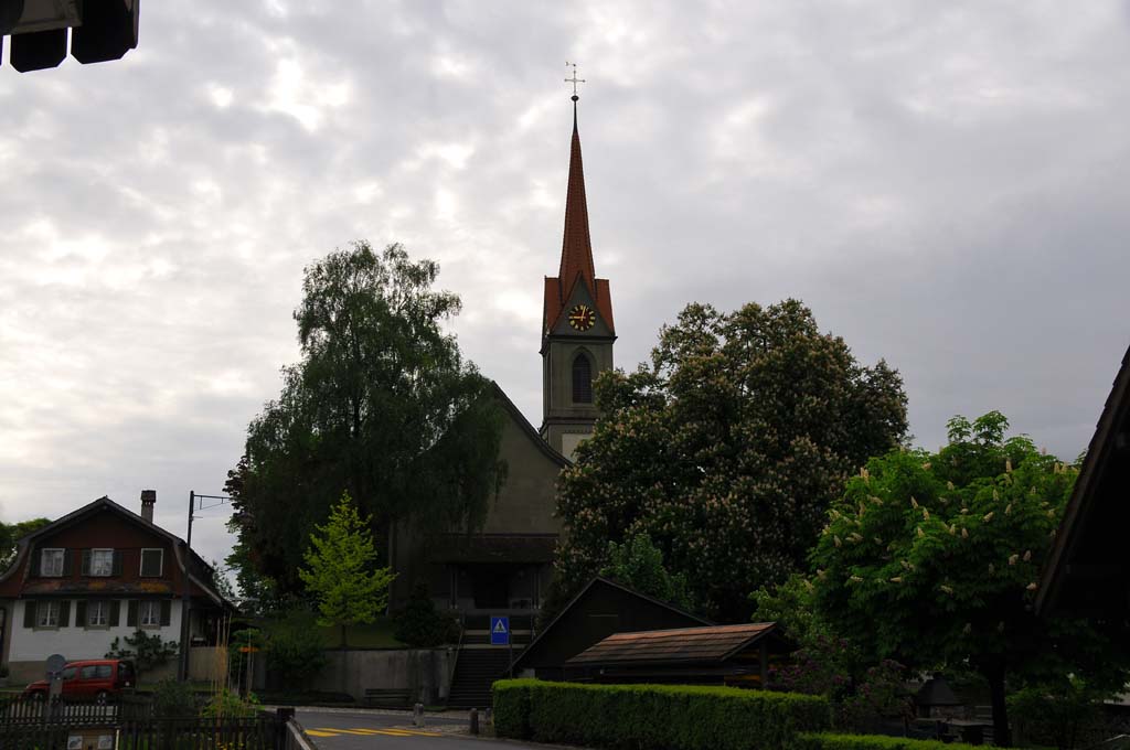 Die Kirche vor wolkenverhangenem Himmel.