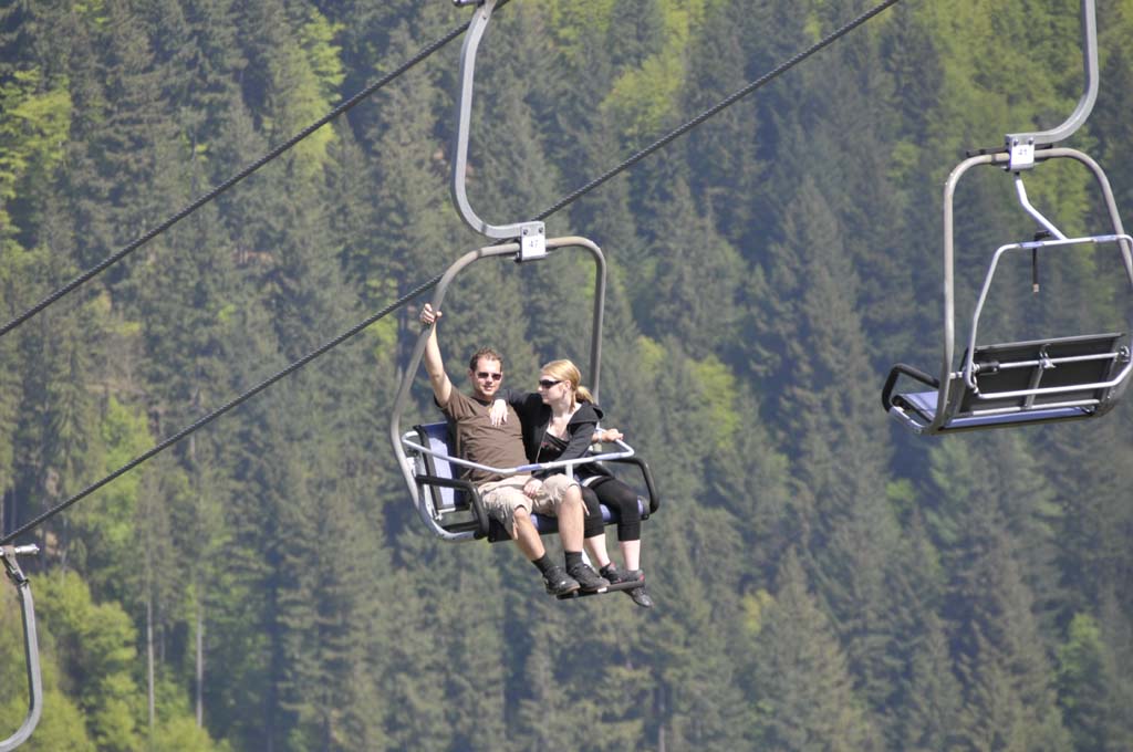 Zwei Musikanten mit der Sesselbahn auf dem Weg nach oben.