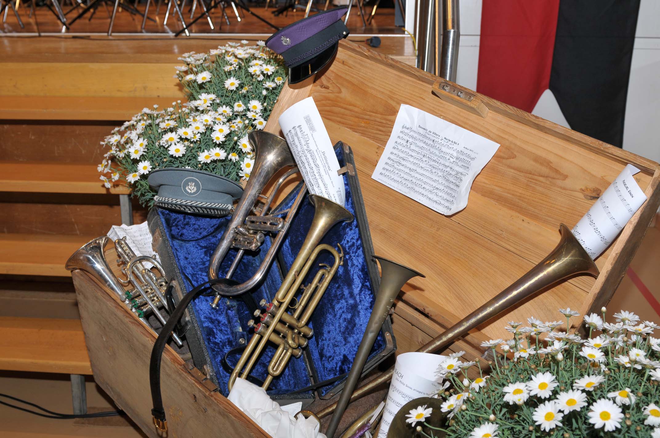 Alte Instrumente in einer Blumen geschmückten Kiste neben der Bühne.
