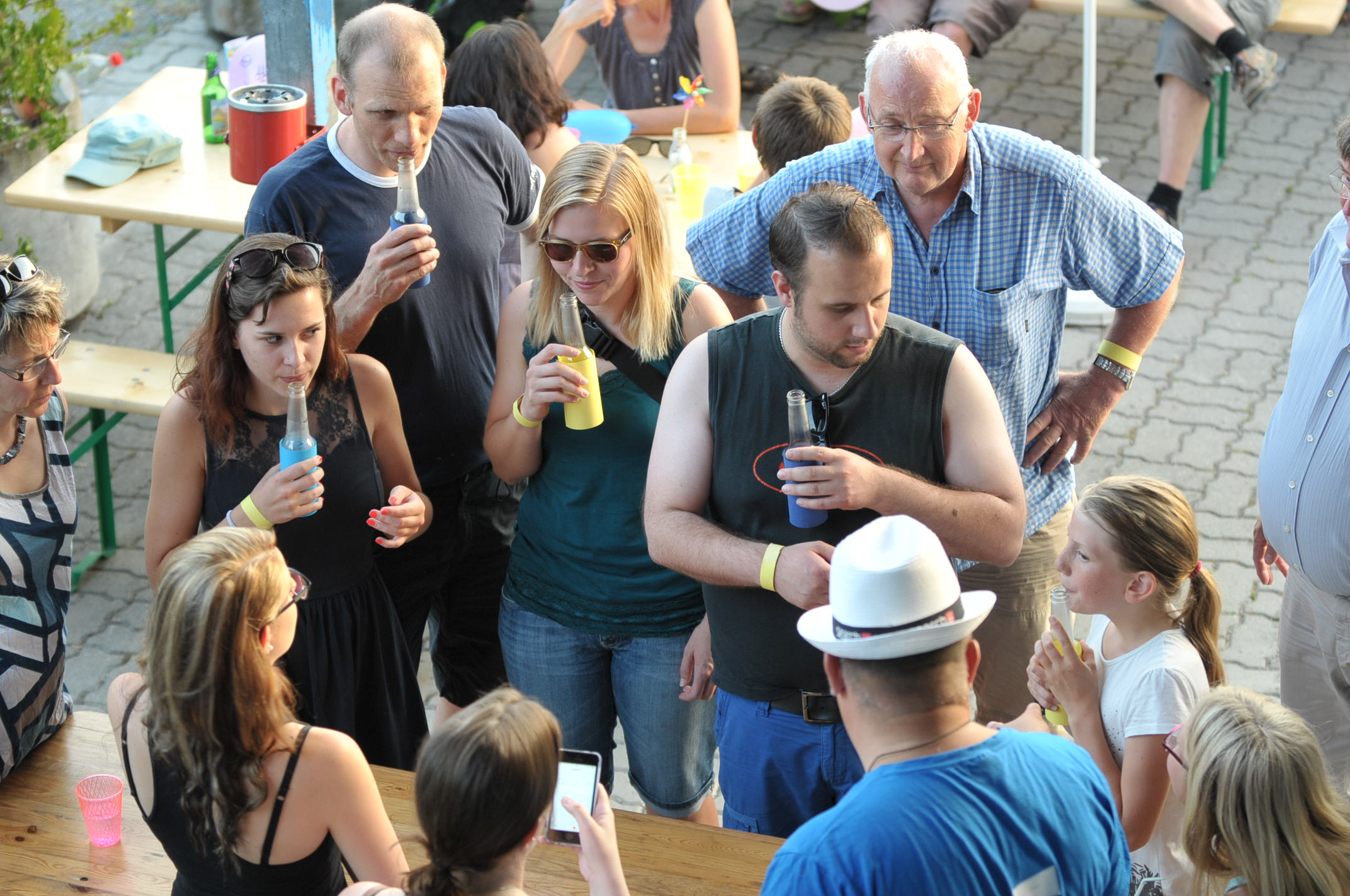 Personengruppe, welche um einen Tisch steht. (von oben aufgenommen)