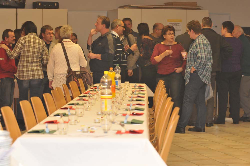 Langer Tisch. Im Hintergrund ist die Gesellschaft am Apérölen.