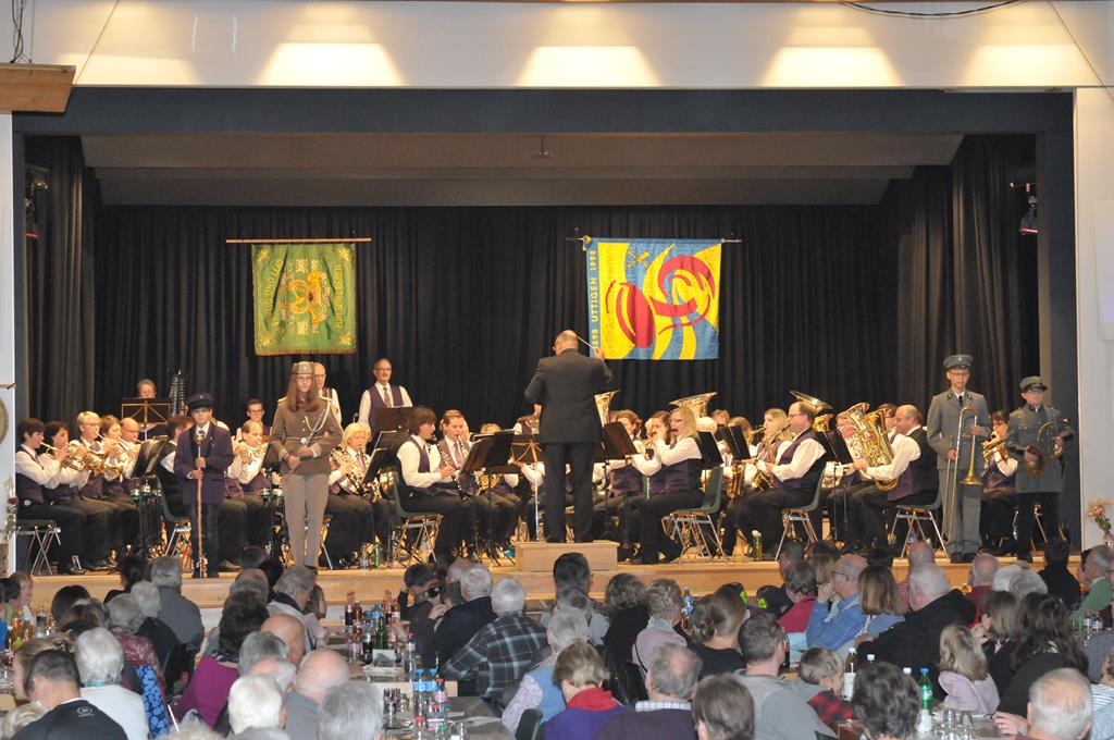 Unsere alten Uniformen werden präsentiert. ("Suchbild", da die Personen auf der Bühne sehr weit weg sind.)