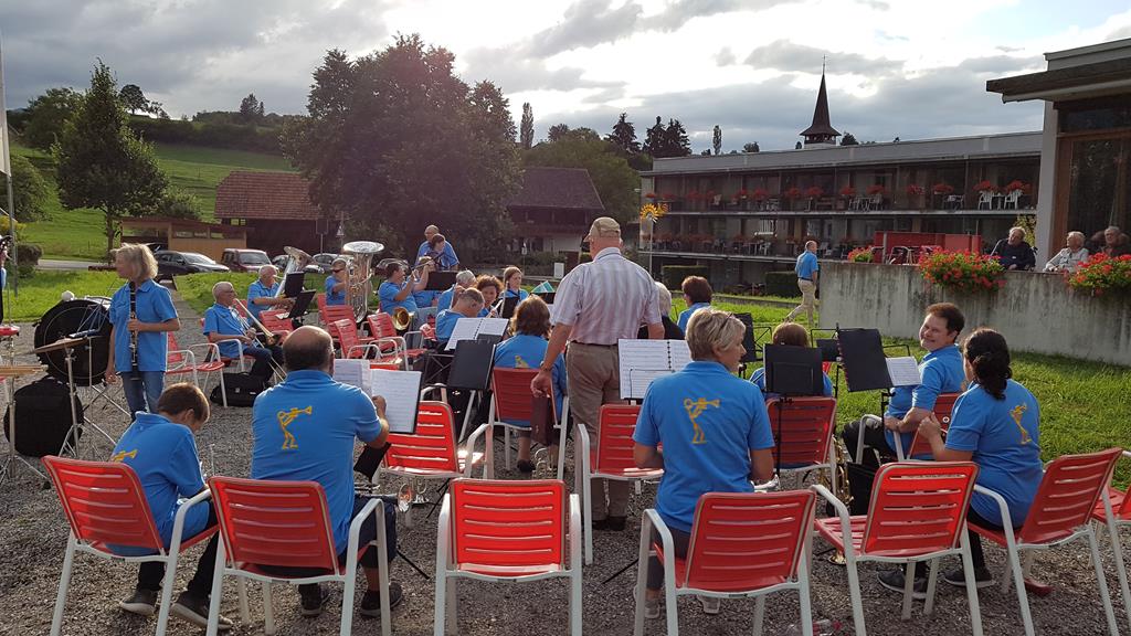 Die MGU sitzt mit blauen T-Shirts auf roten Stühelen.