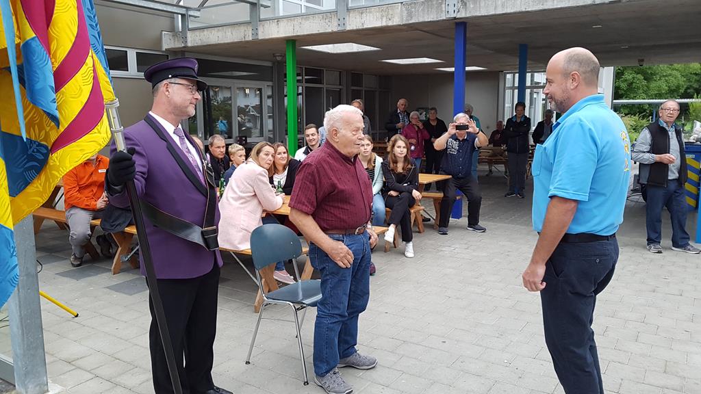 Der Präsident, Oliver Hofer, gratuliert unserem früheren Fähnrich, Kurt Schwendimann. Daneben steht der aktuelle Fähnrich, Martin Kiener, mit der violetten Uniform und unserer Fahne.